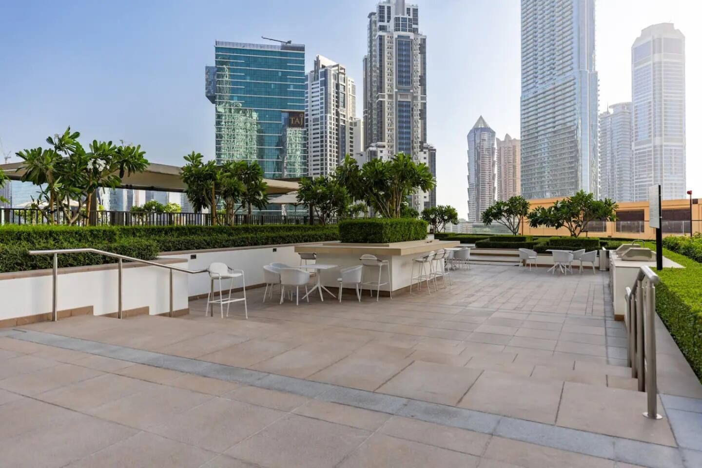 En takterrass med utomhusmöbler och utsikt över höga byggnader.