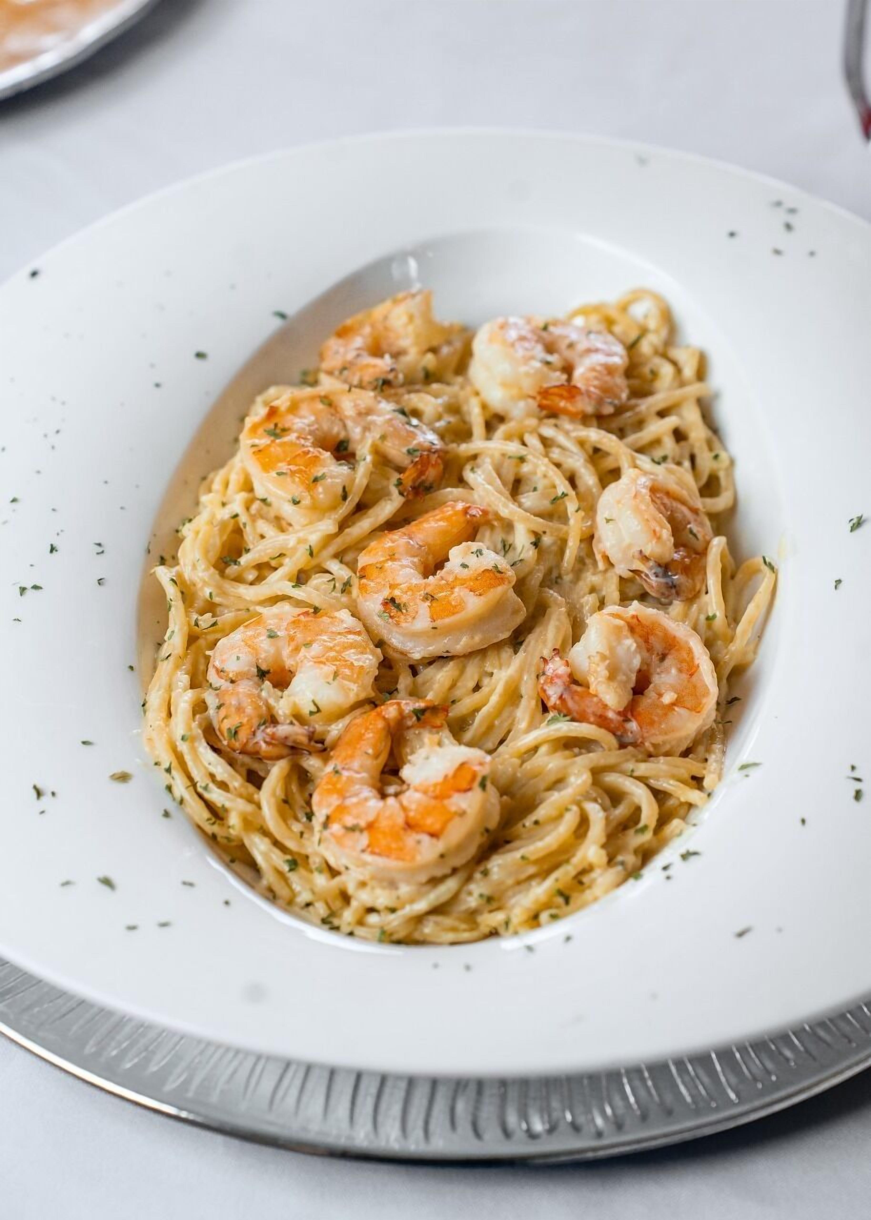 A plate of pasta with shrimp.