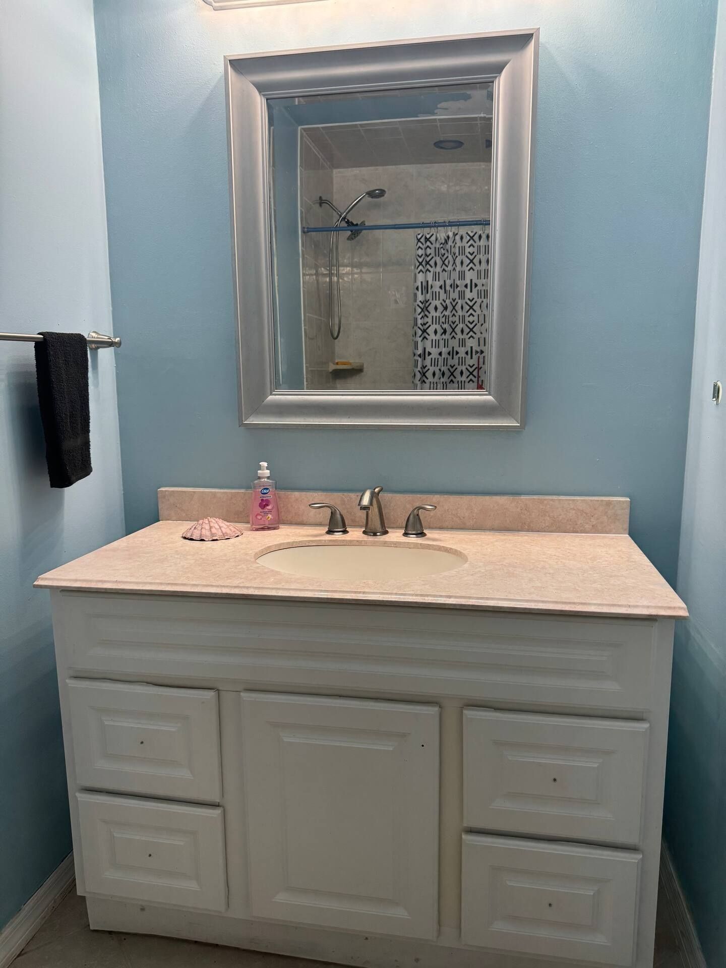 Une salle de bain équipée d’un lavabo, d’un miroir et d’un porte-serviettes.