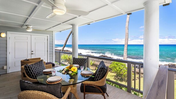An outdoor dining area with a glass table, wicker chairs, and a view of the ocean. - Luxury Oceanfront Panoramic Views, Private Sauna & Beach Access - Vrkcv (Kailua-Kona)