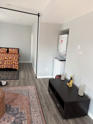 A bedroom with a bed, a dresser, a TV, and a rug. - Welcoming 2-bed/1ba walk-out basement in Castle Pines (Castle Pines)