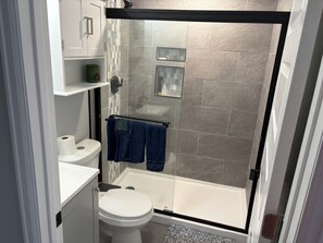 Une salle de bain moderne équipée d’une douche, de toilettes et d’un lavabo.
