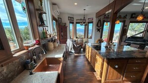 Una cocina espaciosa con una isla grande, armarios de madera y vistas a las montañas.