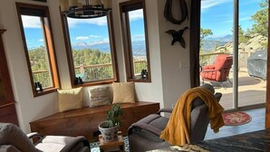 Una sala acogedora con un ventanal grande, un banco de madera y vistas al exterior.