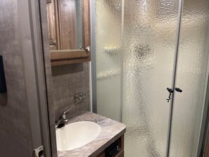 Regadera, secadora de cabello, toallas, papel de baño 