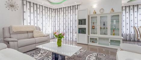 A modern living room with a sofa, a coffee table, and a cabinet with glass doors.