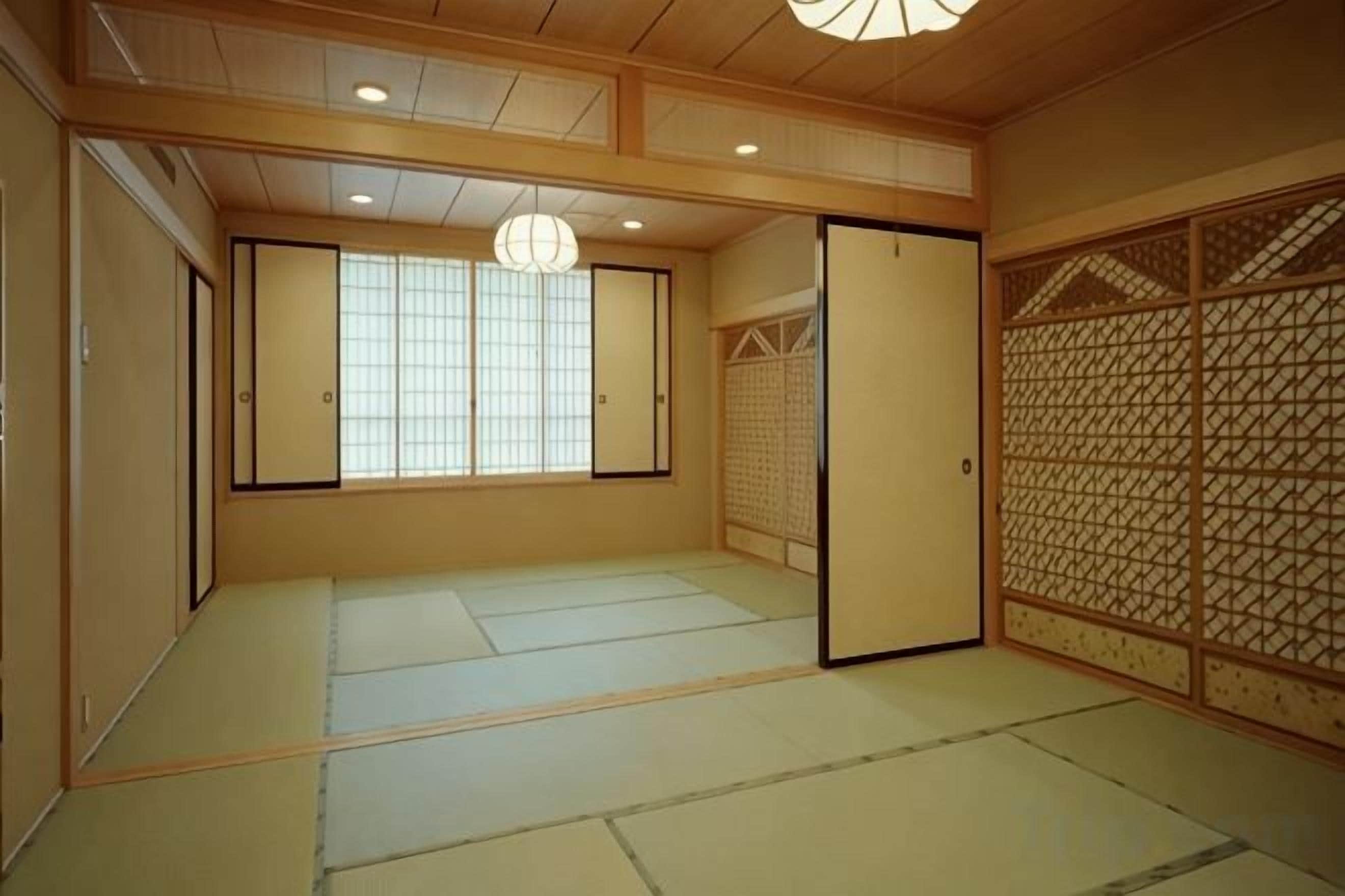 A traditional Japanese room with tatami flooring, sliding doors, and a shoji screen.