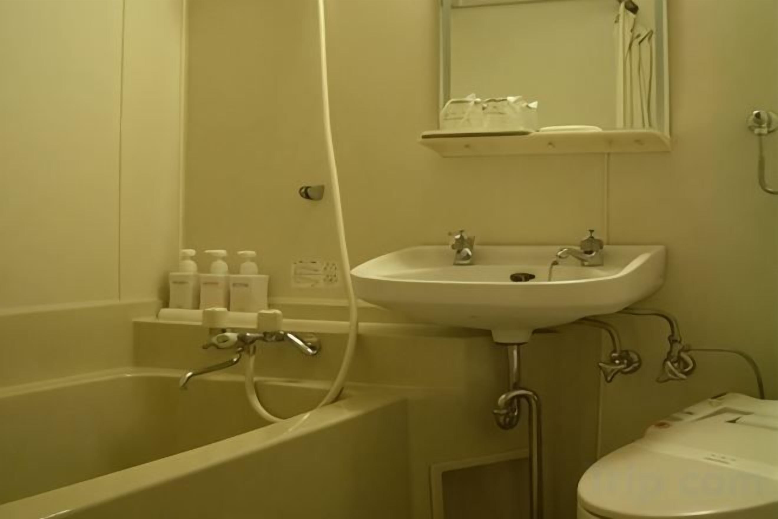Um banheiro com banheira, pia e vaso sanitário.