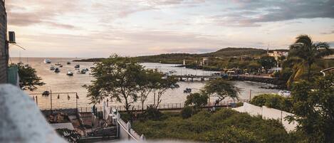 Vista costera con barcos, un puente y un paseo marítimo.