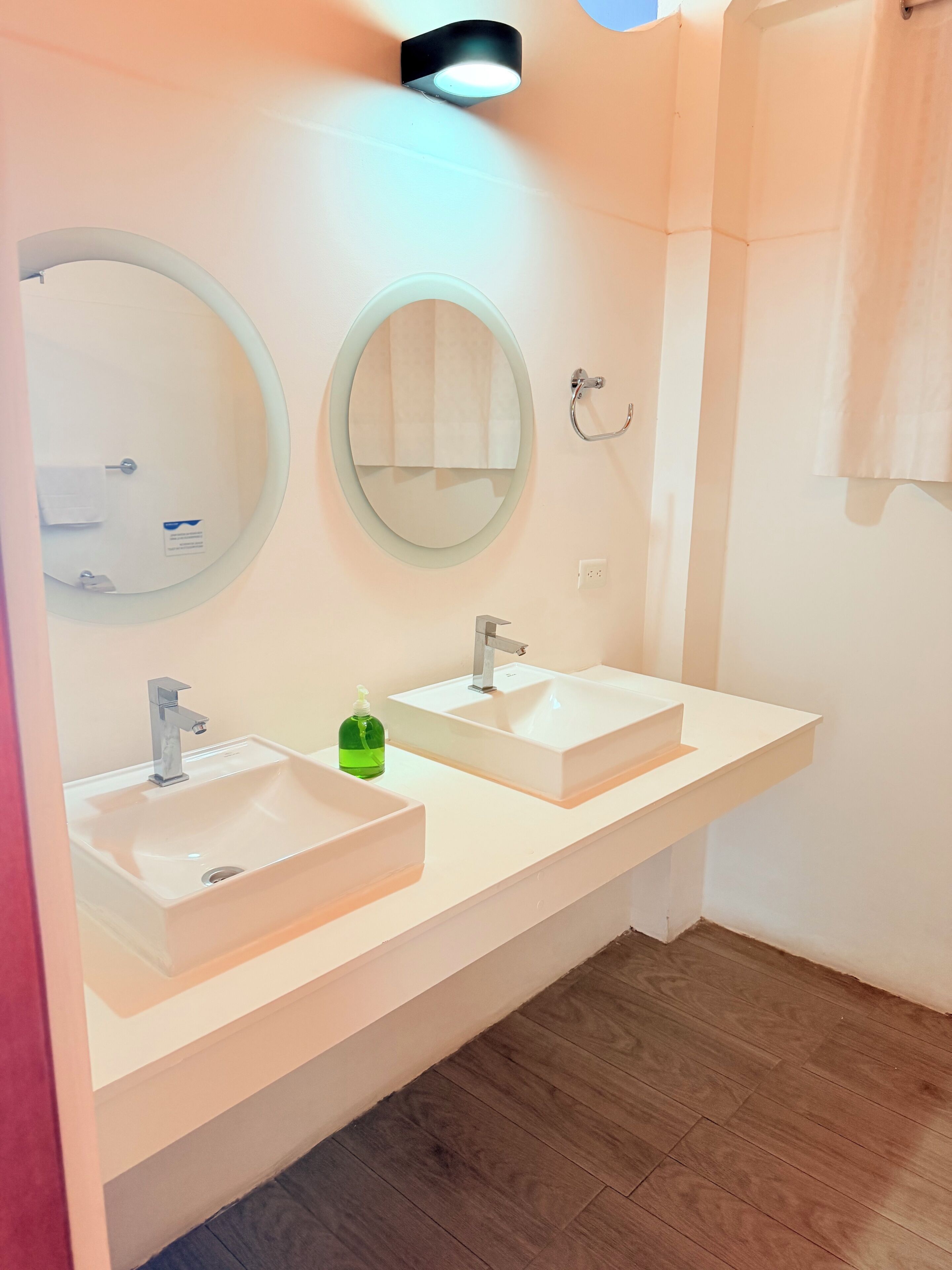 Ein Badezimmer mit zwei Waschbecken, einem Spiegel und einem Handtuchhalter.