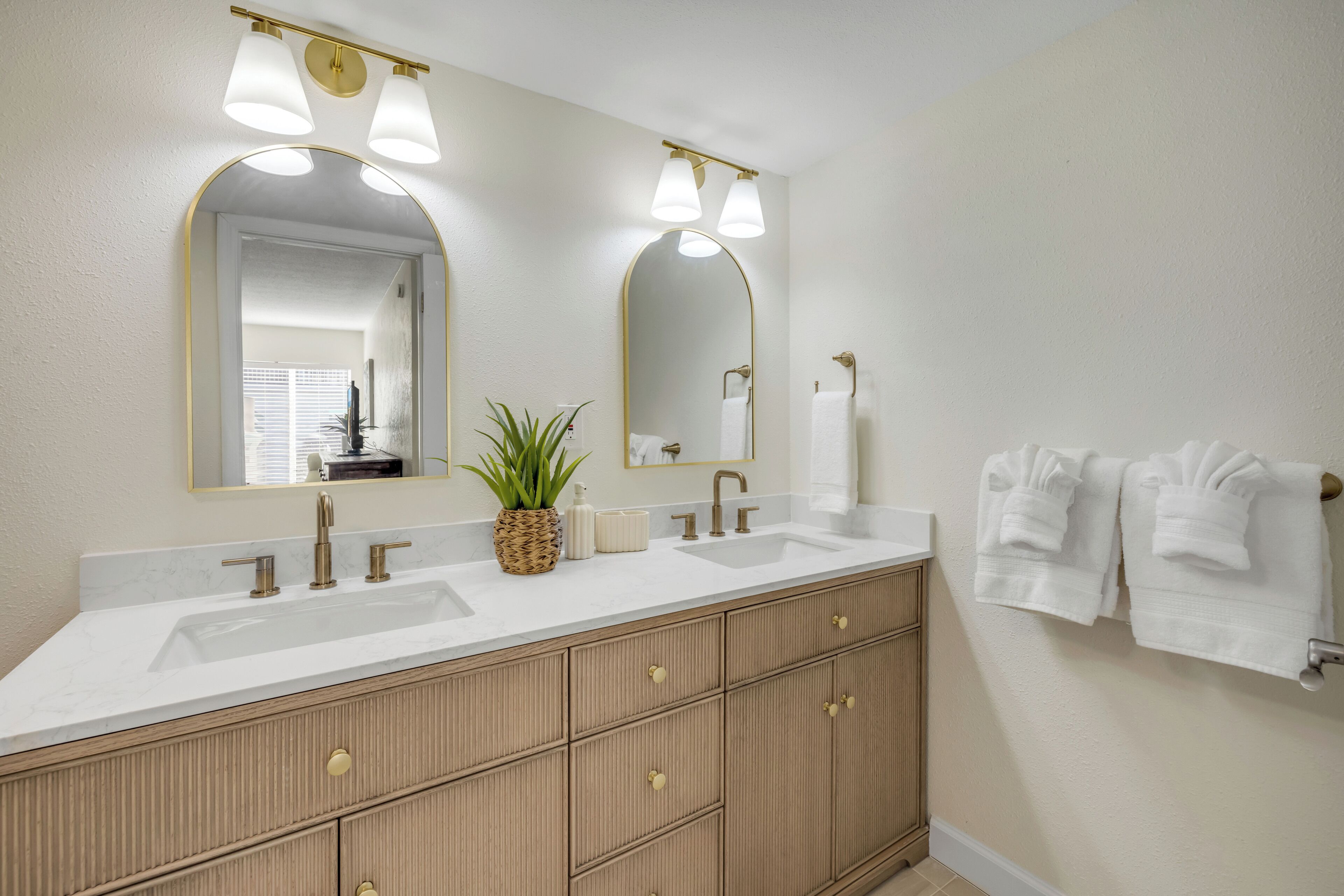 A bathroom with two sinks, a large mirror, and a towel rack.