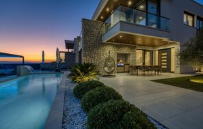 A modern house with a stone facade, a pool, and outdoor furniture. - Lovely home in Crikvenica (Crikvenica)