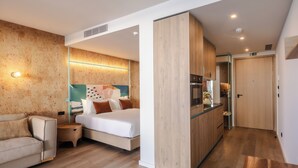 Una habitación de hotel moderna con cama, sofá, kitchenette y baño.