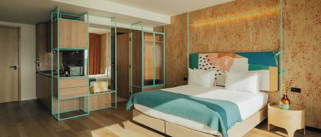A hotel room with a bed, a nightstand, a wardrobe with open doors, and a bathroom visible through the wardrobe doors.