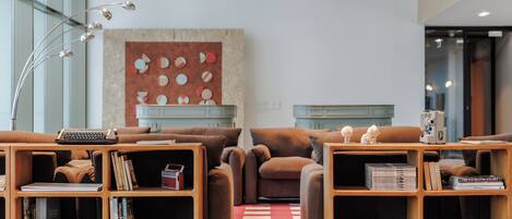 Un salon moderne avec deux canapés, une table basse et une bibliothèque.