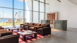 A spacious living area with leather sofas, a coffee table, and a fireplace. - Upon Harbor - Seixal Bay Hotel (Seixal)