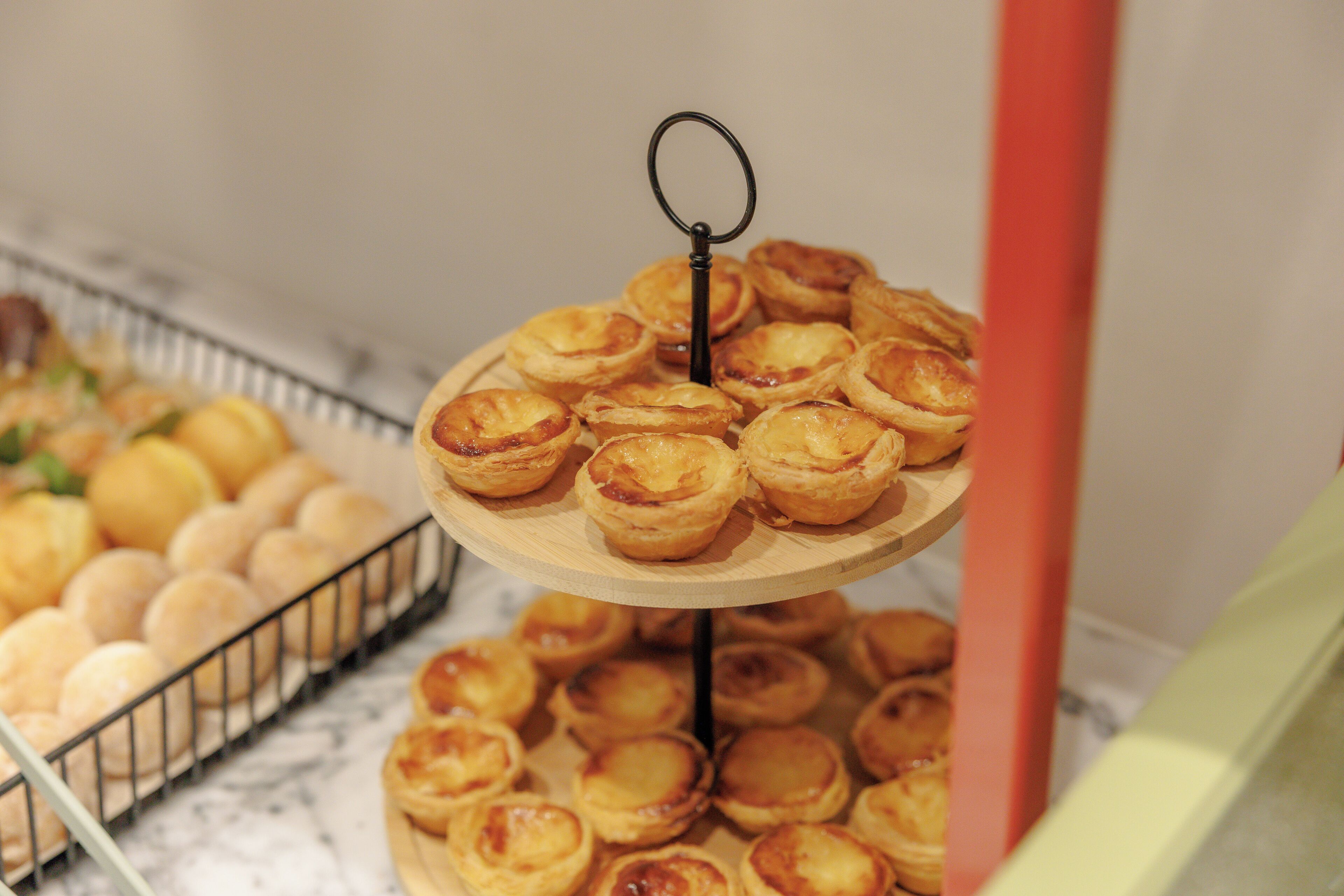 Uma exposição em camadas de doces, incluindo tartes e pães, sobre uma bancada de mármore.