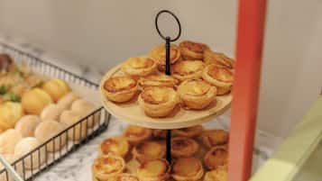 Uma exposição em camadas de doces, incluindo tartes e pães, sobre uma bancada de mármore.