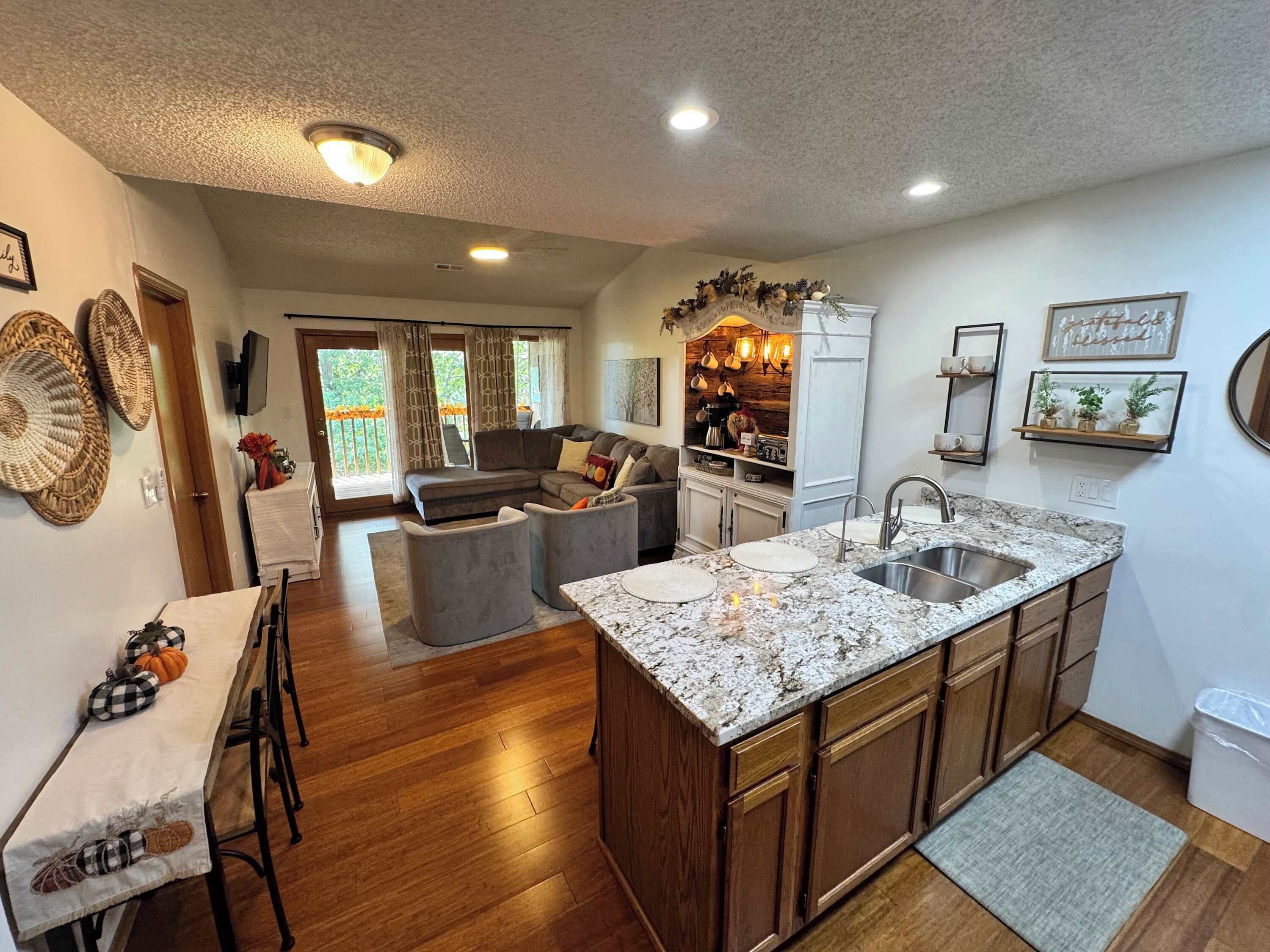 A spacious kitchen with a large island, wooden cabinets, and a dining area with a table set for two.