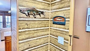 Un coin de pièce avec un mur en bois orné d’une décoration représentant un poisson et d’une plaque.