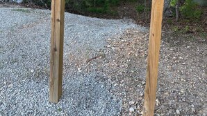 Un panneau indicateur en bois portant l’inscription « SENTIER NATURE » et, en dessous, un panneau d’avertissement indiquant : « ATTENTION AUX OURS ».