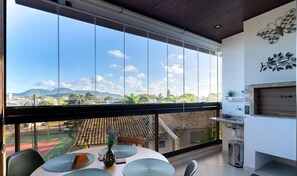 A dining area with a view of mountains and a sports field. - Apt w/ Gourmet Balcony 300m From Beach Cms0202 (Florianópolis)