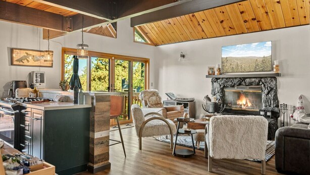 Una cucina moderna con un'isola grande, un caminetto e un'area pranzo con vista sull'esterno.