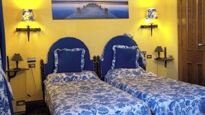 Een kamer met twee bedden, elk met een hoofdbord en bijpassende lampen.