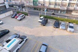 A parking lot with multiple cars and a building in the background. - Nicha Residense Hotel (Bangkok)