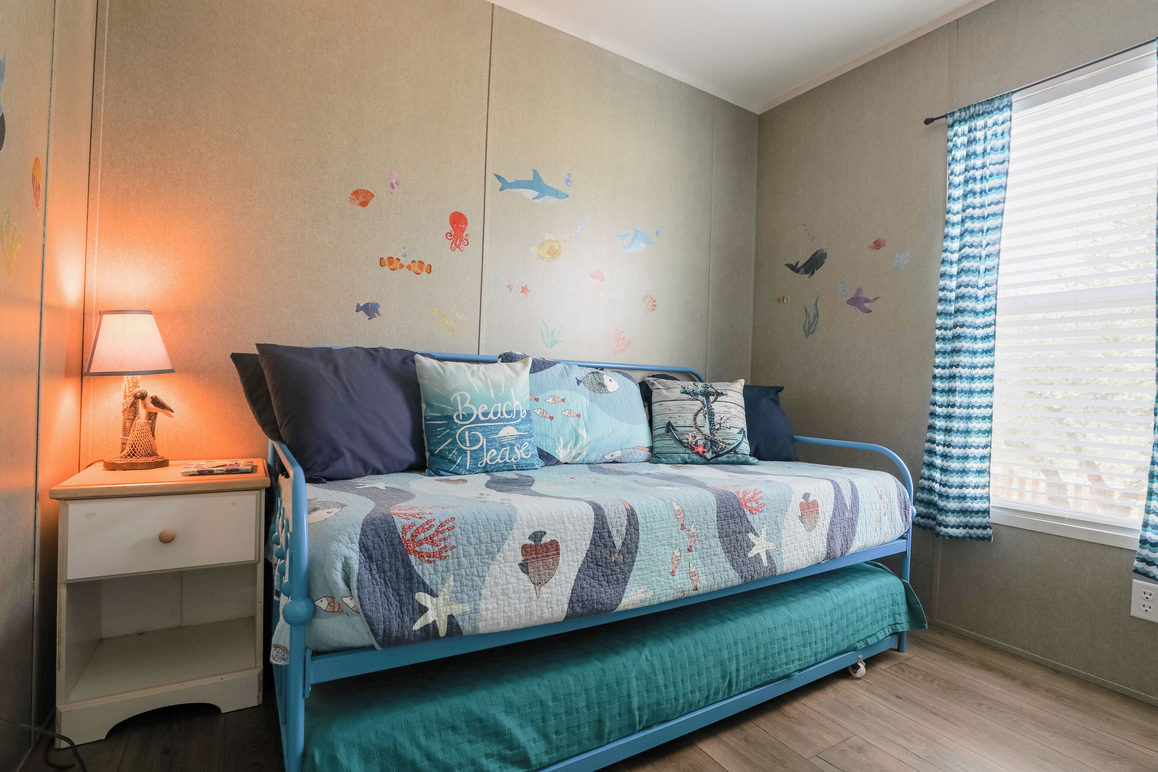 A bedroom with a bed, nightstand, and a lamp.