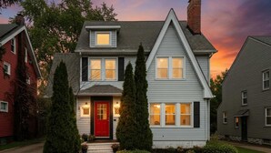 A two-story house with a red front door, white trim, and a chimney. - Hot Tub - Game Room - Professional Design-Backyard (University Heights)
