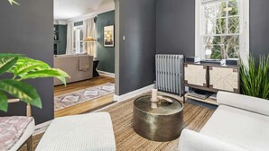 A modern living room with dark walls, a white sofa, a round coffee table, and a radiator. - Hot Tub - Game Room - Professional Design-Backyard (University Heights)