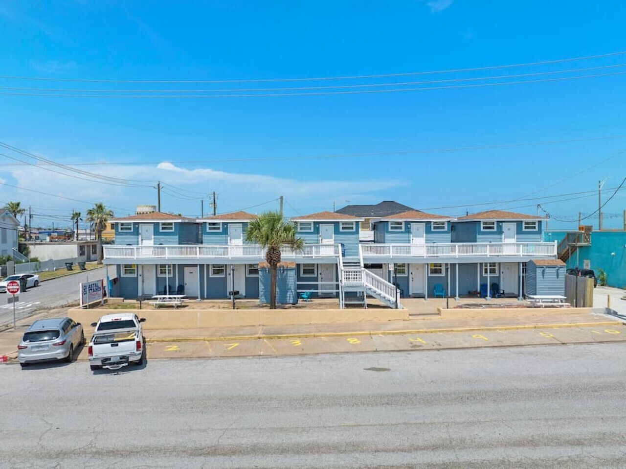 A motel with a two-story structure, a covered parking area, and a visible signboard.