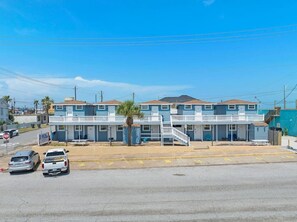 A motel with a two-story structure, a covered parking area, and a visible signboard. - Charming Studio on Seawall, Near Cruise Terminal (Galveston)