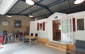 A mobile home with a dining area, kitchen, and a large window.