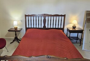 A bed with a wooden headboard, two bedside tables with lamps, and a red bedspread. - Gîte 35 - SAINT-PIERRE-DE-TRIVISY (SAINT-PIERRE-DE-TRIVISY)