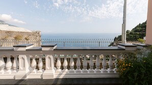 A balcony with a railing, overlooking a coastal area with a clear sky and distant sea. - Villa Tirrena by My Villa Collection (Positano)