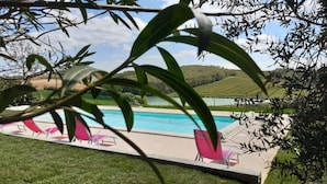 Un espace piscine offrant une vue sur un lac et des collines en arrière-plan.