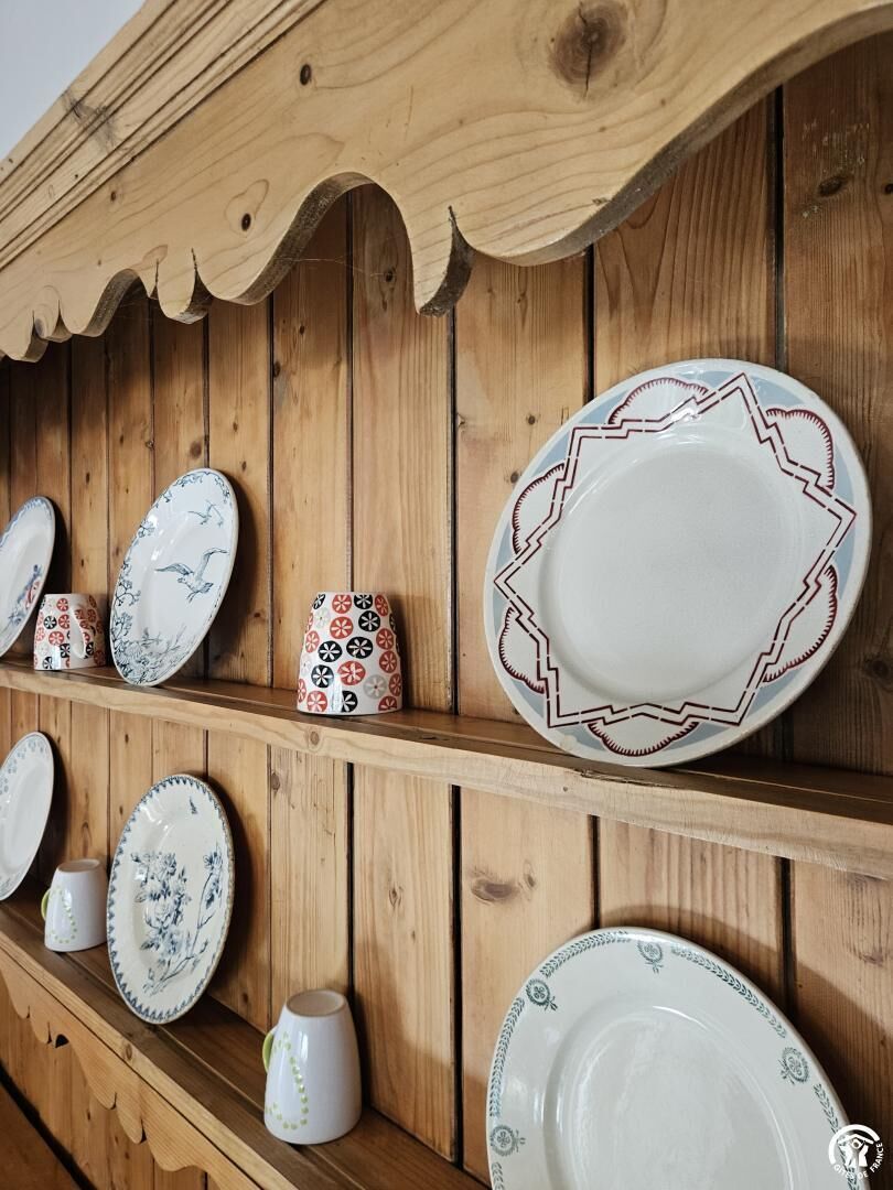 A wooden wall with shelves holding various plates and cups.