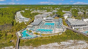 Un resort con múltiples piscinas, una piscina central grande y varias edificaciones.