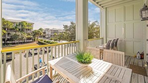 Ein Balkon mit Holztisch, Stühlen und einer Topfpflanze.