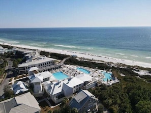 A resort with multiple buildings, a beach, and a swimming pool area.