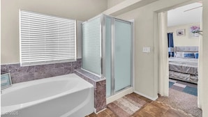 A bathroom with a bathtub, shower enclosure, and a window with blinds. - 3-bedroom house in charming North Las Vegas with AC (North Las Vegas)