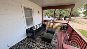 A covered porch with a seating area, a patterned rug, and a view of the street. - Hunters and Anglers welcomed (Palisade)