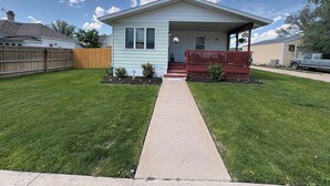 A single-story house with a front porch, a small garden, and a clear sky. - Hunters and Anglers welcomed (Palisade)