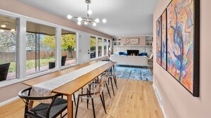 A modern kitchen with a dining area, large windows, and a fireplace. - Stylish South Hill Getaway | Bar & Game Room (Spokane)