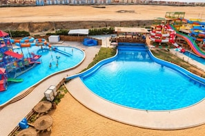 A large swimming pool with multiple water slides and a separate children's play area. - Gloria Aqua Park (Aswan)