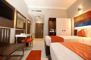 A hotel room with a bed, a desk, a chair, a mirror, a wardrobe, and a painting on the wall. - Gloria Aqua Park (Aswan)