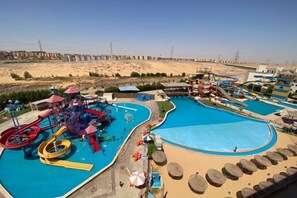 A water park with multiple pools and slides, surrounded by a sandy landscape. - Gloria Aqua Park (Aswan)