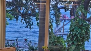 Una mesa de comedor de madera con vista al mar y una terraza.